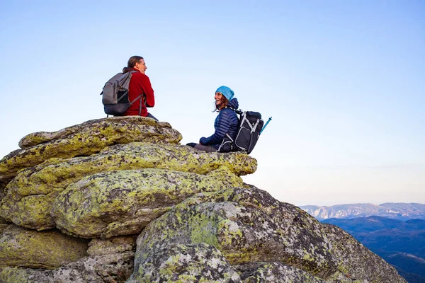 远足的夫妇坐在岩层上欣赏风景 — 图库照片