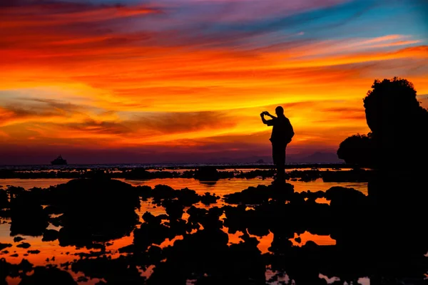 Silhueta homem assistindo incrível pôr do sol na praia em Krabi Th — Fotografia de Stock