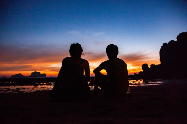 夫妇剪影观看惊人的日落在甲米海滩 — 图库照片