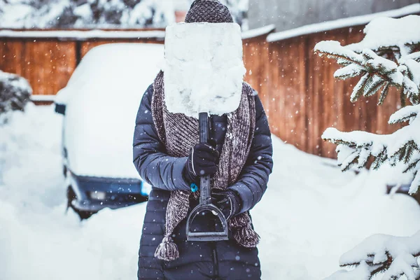 Kobieta z łopatą czyszczenia śniegu aeound samochodu. Łopaty zimowe. Ponownie — Zdjęcie stockowe