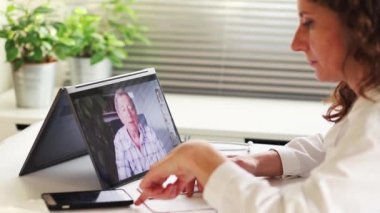 Teletıp konsepti. Yaşlı bir adam internette doktoruyla konuşuyor. 