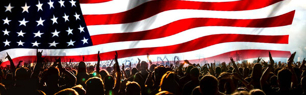 толпа празднует День Независимости. Флаг США на фоне фейерверков на 4 июля
