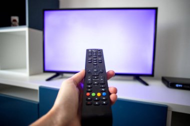 Evde televizyon izleyip uzaktan kumandaya odaklanmak