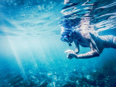 Kadın berrak tropikal sularda şnorkelle yüzüyor - aktif tatil