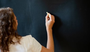 Okulun konsept öğretmenine karatahtanın önünde