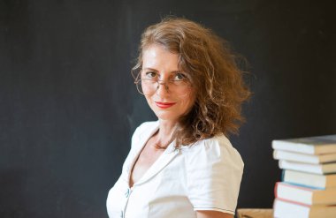 Okulun konsept öğretmenine karatahtanın önünde