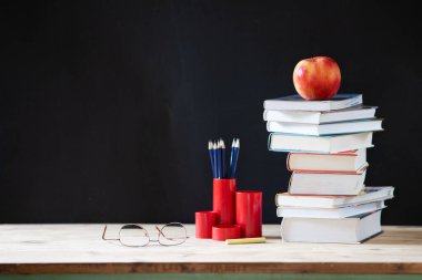 Kara tahtaya karşı okul konsepti kitap yığınına