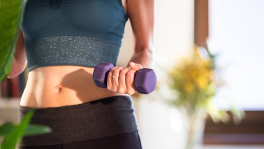 Dambılı kadın evde egzersiz yapıyor.