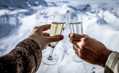 Şampanya içen ve kış tatili yapan çift.