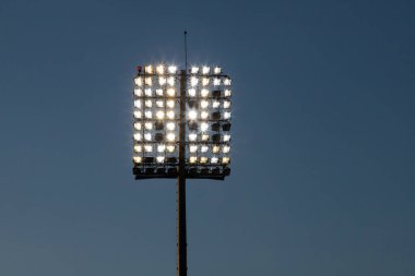 Stadyum ışıkları yansıtıcı ve koyu mavi gökyüzü