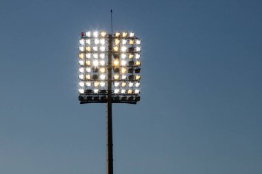 Stadyum ışıkları yansıtıcı ve koyu mavi gökyüzü