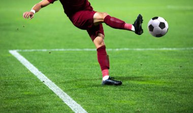 Futbolcu futbolu tekmeliyor