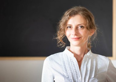 Tahtanın önünde öğretmenim.