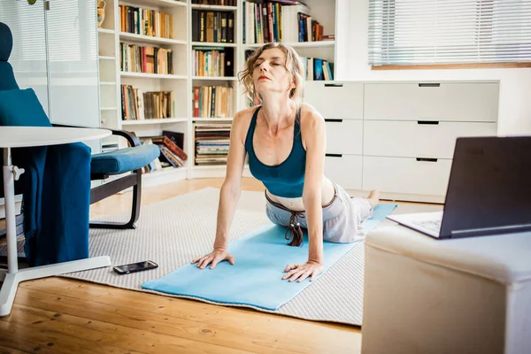 Kvinna Som Gör Yoga Asanas Hemma Med Bärbar Dator — Stockfoto