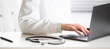 Dizüstü bilgisayar tele tıp konsepti üzerinde çalışan doktorların elleri