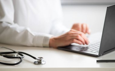 Dizüstü bilgisayar tele tıp konsepti üzerinde çalışan doktorların elleri