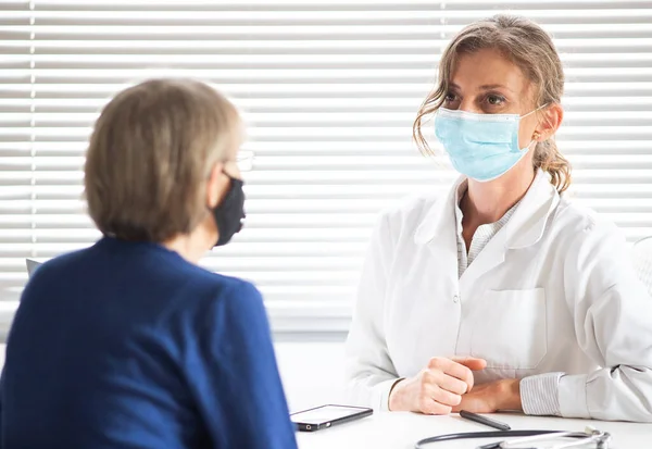 Kadın Doktor Tıbbi Maske Takan Bir Hastaya Danışıyor — Stok fotoğraf