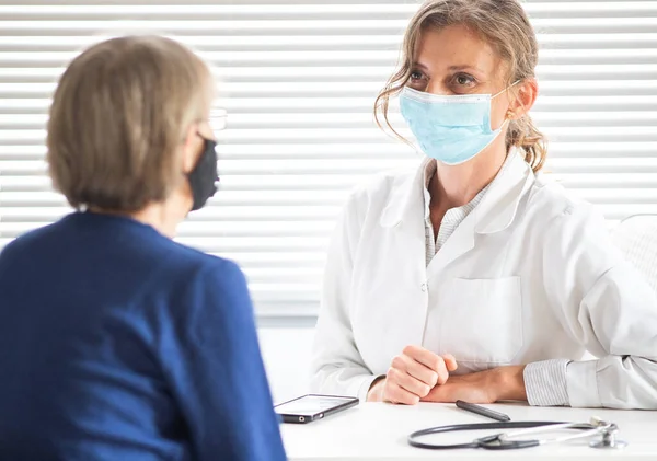 Kadın Doktor Tıbbi Maske Takan Bir Hastaya Danışıyor — Stok fotoğraf