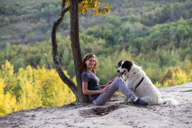 Kadın ve köpek açık havanın keyfini çıkarıyorlar.