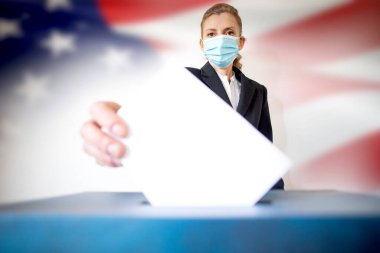 Amerikan bayrağı seçimleri sırasında maske takan kadınlar oy kullandı.