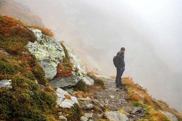霧の多い山でハンサムな男性ハイカー社会的距離 — ストック写真