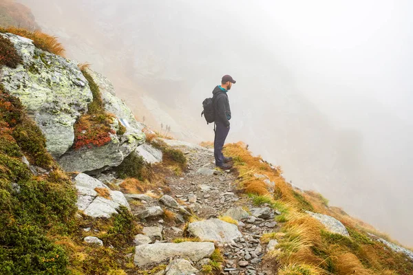 霧の多い山でハンサムな男性ハイカー社会的距離 — ストック写真
