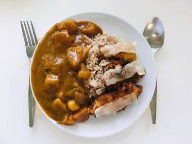 Gevrek kızarmış domuz eti ile Japon köri pirinç, üst görünümü ve beyaz arka plan 