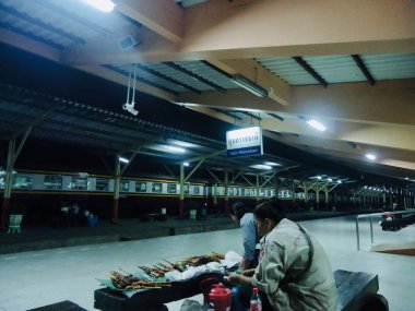 Sabah tren pazarında ızgara tavuk satan kadın satıcı bekliyor.