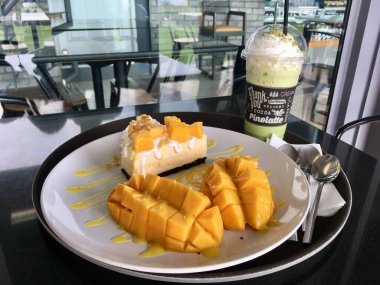 Taze mangolu mangolu cheesecake ve frappe içeceği, Kafe 'de tatlı siparişinin tadını çıkarın. 