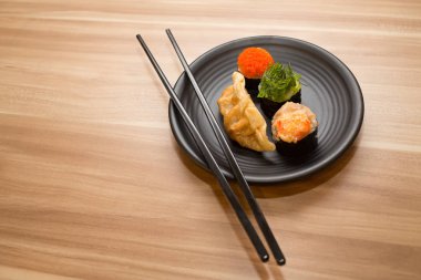 Ahşap arka planda bir tabakta suşi