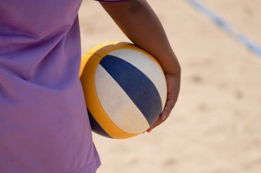 bir plaj voleybolu sporcusu elinde plaj voleybolu holding