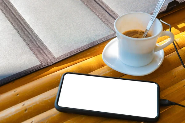 Mobiele telefoonoproep geplaatst op een bamboe tafel in de ochtend met een — Stockfoto