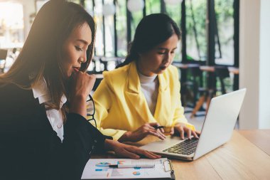 İş konsepti. İş adamları başarılı takım çalışmalarının sonuçlarını gösteren çizelge ve grafikleri tartışıyor.