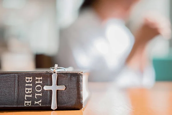 Christian woman praying on holy bible. Hands folded in prayer a holy bible in church concept