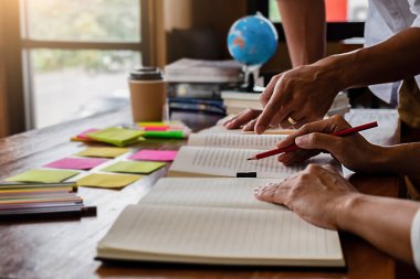 Eğitim kavramı. Öğrencilerin eğitim ve kampüs kavramı beyin fırtınası. Konu kitaplar ders kitapları tartışmak ve not defterine yazma öğrencilerin kapatın. Seçici odak.