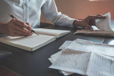 Faturaları ve hesap makinesi olan kadın. Faturaları Office masada hesaplamak için hesap makinesi kullanan kadın. Maliyetleri hesaplama.