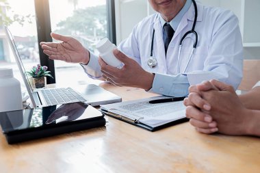 dikkatle dinliyor bir erkek hasta hasta belirtiler açıklayan veya onlar evrak tartışmak birlikte bir Danışma süreci gibi bir soru soran doktor
