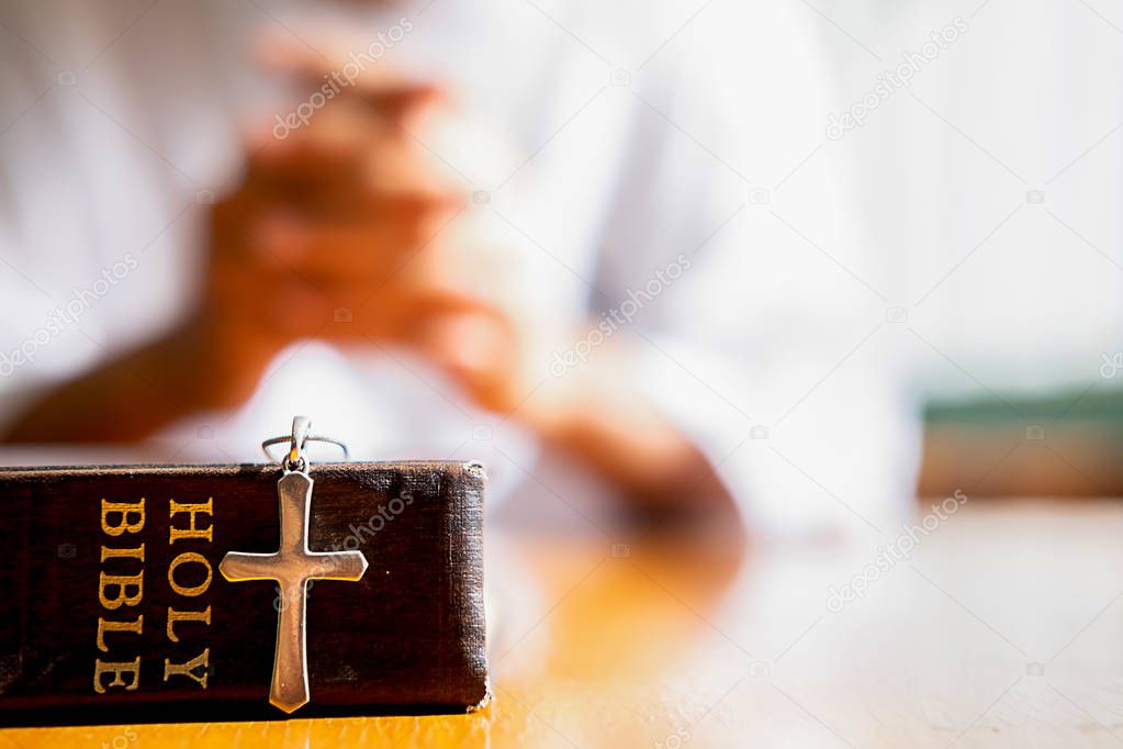 Holy bible and cross on table with Christian woman hoping for better. Asking God for good luck, Success, Forgiveness. Power of religion, Belief, Worship.