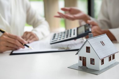 Emlakçı ve müşteri ev, sigorta ya da kredi sözleşmesi imzalıyor.