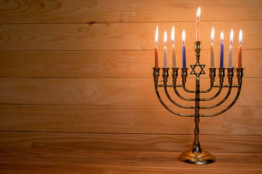 Ahşap arka plan ile Yahudi tatil için renk mumlar yanan ile Hanukkah menorah.