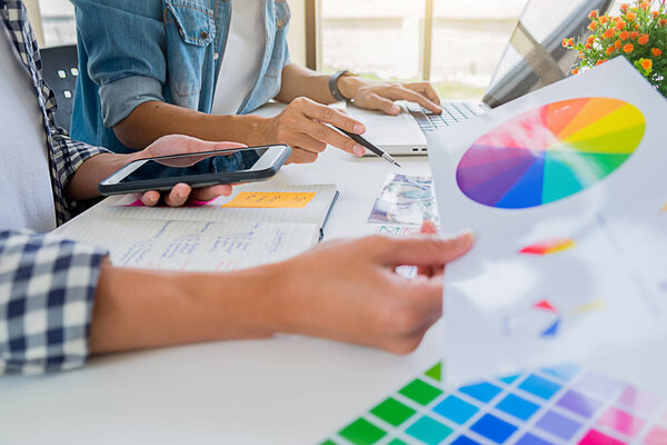 Азиатская команда дизайнеров рекламы обсуждает идеи в офисе
.