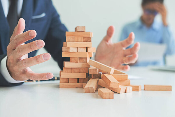 Problem Solving Business can't stop effect of dominoes continuous toppled with business team feeling sad and stress in office background. Failure Business Concept.