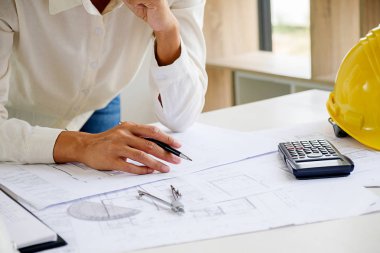 Bir ofiste bir tablet bilgisayardaki bilgileri denetlenirken bir plan mühendisleri tartışmak.