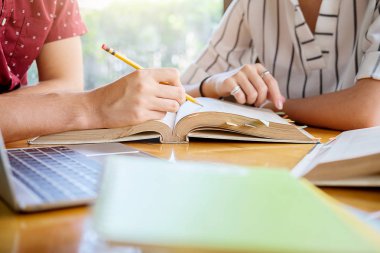 Eğitim kavramı. Öğrencilerin eğitim ve kampüs kavramı beyin fırtınası. Konu kitaplar ders kitapları tartışmak ve not defterine yazma öğrencilerin kapatın. Seçici odak.