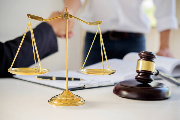 Судья молоток с адвокатами юстиции, собирающими команду в юридической фирме на заднем плане. Понятия права.