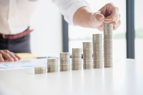 Rows of coins for finance and banking concept with business man and woman.hand putting money coin stack growing business