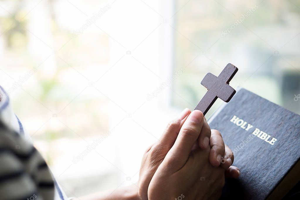 Christian woman praying on holy bible. Hands folded in prayer a holy bible in church concept