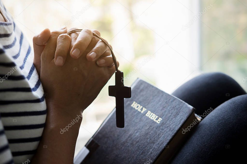 Christian woman praying on holy bible. Hands folded in prayer a holy bible in church concept