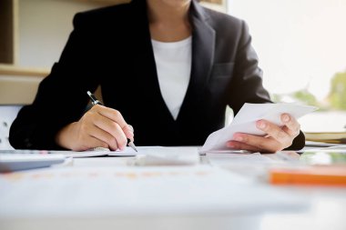 Faturaları ve hesap makinesi olan kadın. Faturaları Office masada hesaplamak için hesap makinesi kullanan kadın. Maliyetleri hesaplama.