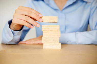 El iş adamı planlama, risk ve iş stratejisi. Bir kule üzerinde ahşap blok yerleştirme kumar iş.